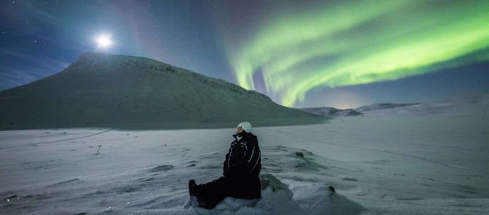 A person watching the Northern Lights near Saana Fell