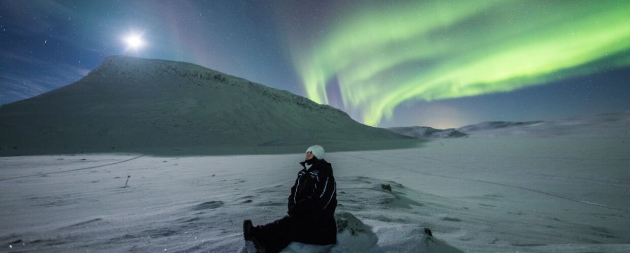 A person watching the Northern Lights near Saana Fell
