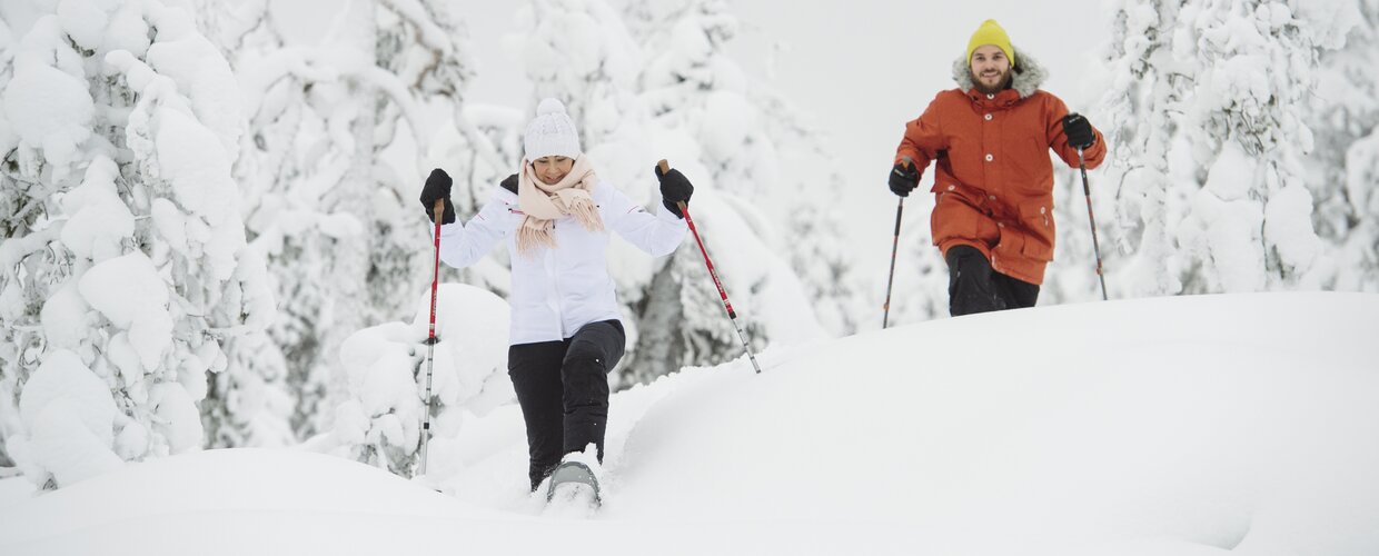 A couple snowshoeing in the forest