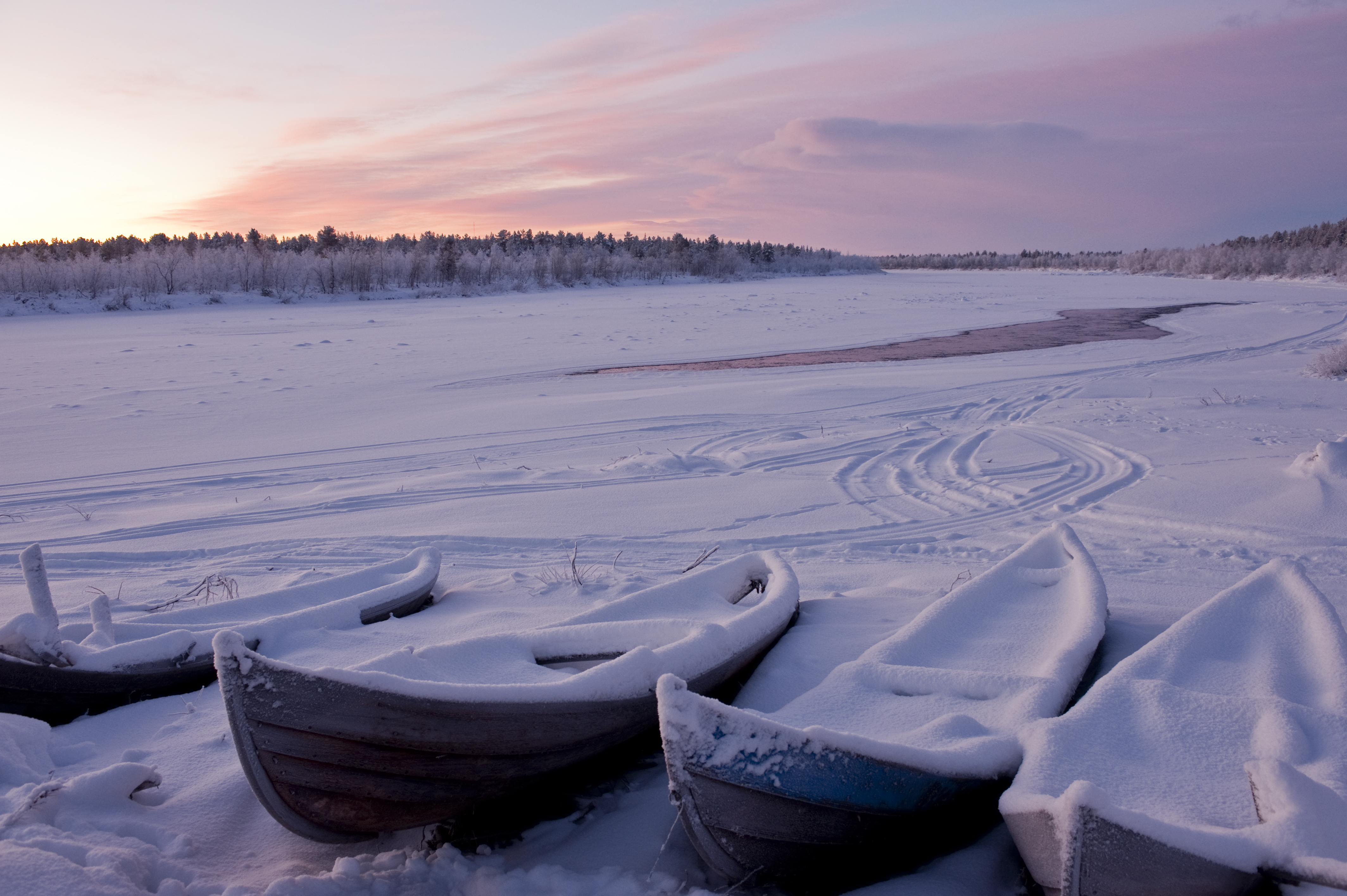 The frozen river Muonio in Karesuando with snow-covered canoes