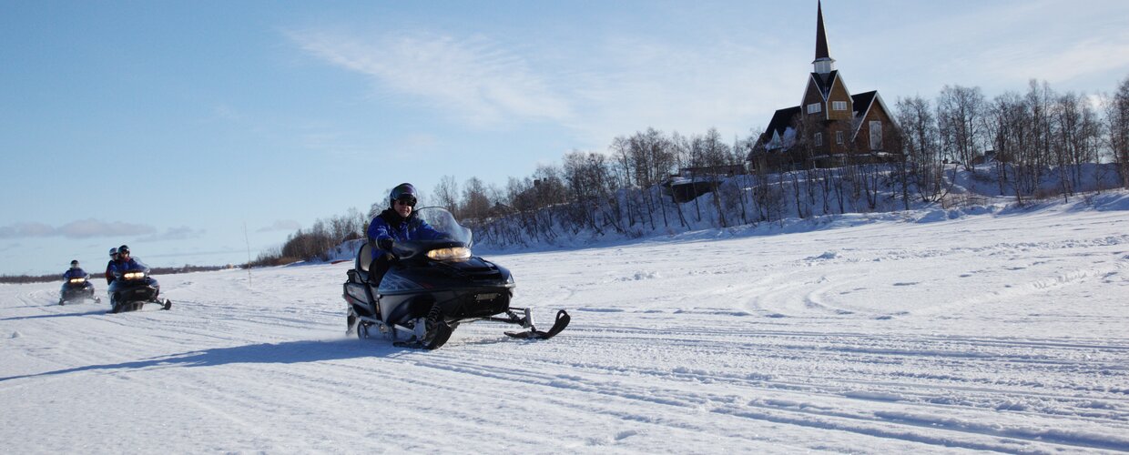 Snowmobilers on frozen Muonionjoki in Karesuando